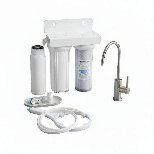 Water filtration system on a kitchen counter with a glass of water and cleaning brush.