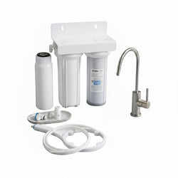 Water filtration system on a kitchen counter with a glass of water and cleaning brush.